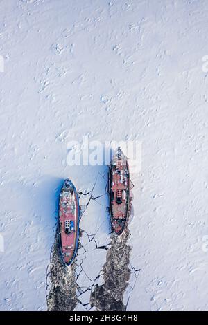 Due rompighiaccio che rompono il ghiaccio sul fiume in inverno. Veduta aerea della Polonia in inverno Foto Stock