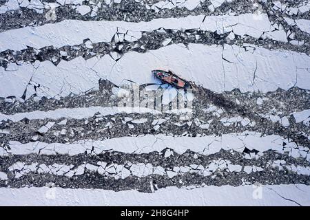 Rompighiaccio che trita ghiaccio sul fiume in inverno. Veduta aerea dell'inverno in Polonia. Foto Stock