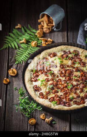 Crostata fatta in casa con funghi e timo. Crostata di chanterelle alle erbe. Crostata rustica di funghi dalla foresta. Foto Stock