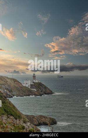 Baily Lighthouse, la penisola di Howth Head in giorno soleggiato e nuvoloso, Seashore, scogliere e rocce, paesaggio, Dublino, L'Irlanda, Foto Stock