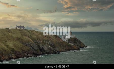 Baily Lighthouse, la penisola di Howth Head in giorno soleggiato e nuvoloso, Seashore, scogliere e rocce, paesaggio, Dublino, L'Irlanda, Foto Stock