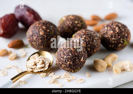 Palle energetiche di cioccolato vegano fatte di noci di anacardi, mandorle, fiocchi d'avena, datteri e polvere di carruba Foto Stock