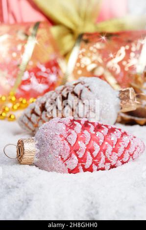 Coni di abete di Natale baubles sulla neve su sfondo luminoso Foto Stock