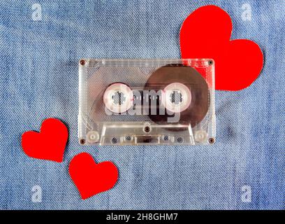 Cassetta audio vintage e cuori rossi sullo sfondo Denim Foto Stock