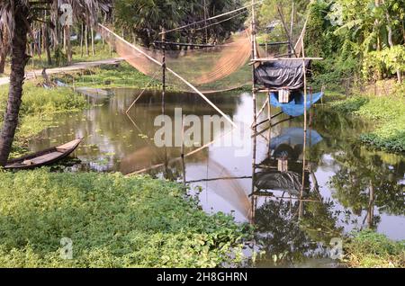 Bei villaggi di Bengala, corpi d'acqua, palme, palme da datteri, reti da pesca, barche da pesca Foto Stock