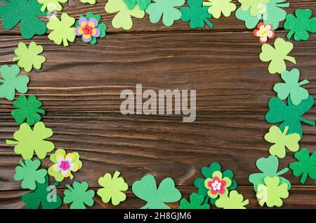 Happy Saint Patrick's mockup del feltro a mano shamrock clover foglie e fiori su sfondo di legno. Foto Stock