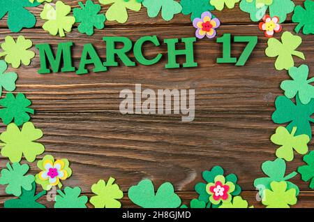 Happy Saint Patrick's mockup del feltro a mano shamrock clover foglie e fiori su sfondo di legno. Foto Stock