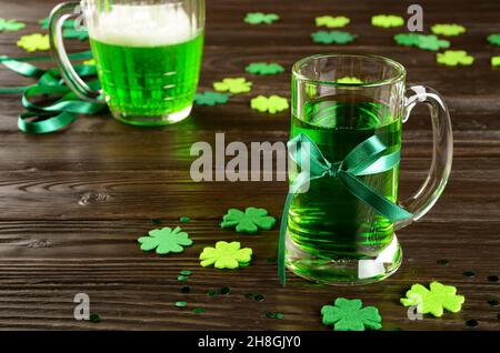Giornata di San Patrizio con pinta di birra verde su un tavolo in legno con scogli in feltro fatti a mano. Spazio di copia Foto Stock