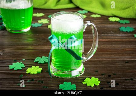 Giornata di San Patrizio con pinta di birra verde su un tavolo in legno con scogli in feltro fatti a mano. Spazio di copia Foto Stock