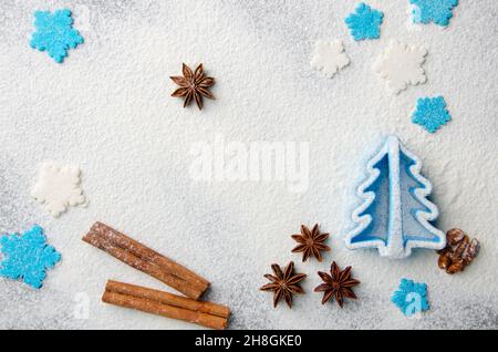 Sfondo della cucina di Natale fatto di farina, bastoncini di cannella, anice, taglierina biscotto e spolverini di zucchero Foto Stock