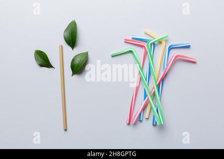 Alternativa ecologica alle lattine di plastica per bevande. Scelta tra plastica vs bambù. Vista dall'alto della paglia potabile in alluminio e plastica. Foto Stock