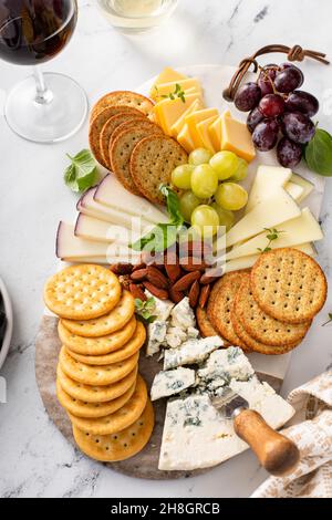 Tavola di formaggio con cracker, noci e uva Foto Stock