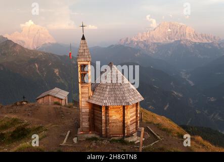 Vista serale dal Monte col DI Lana con cappella al Monte Pelmo e al Monte Civetta, uno dei migliori panorami delle Dolomiti italiane Foto Stock