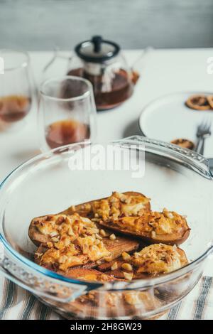 Dessert di pere al forno con formaggio morbido, cannella, miele e noci in forma di cottura. Delizioso dessert autunnale. Scheda verticale. Messa a fuoco selettiva, copia spac Foto Stock