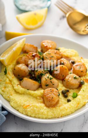 Capesante scottato con grits e salsa di limone Foto Stock