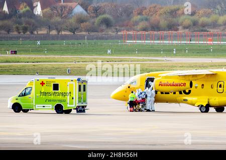 Langenhagen, Germania. 30 Nov 2021. Uno dei due pazienti di Covid 19 viene scaricato da un aereo Dornier 328Jet ADAC da personale di soccorso dell'aeroporto di Hannover per il trasferimento in ospedale tramite trasporto di terapia intensiva. I pazienti gravemente malati provenienti da unità di terapia intensiva in Baviera, Turingia e Sassonia vengono trasportati in zone della Germania settentrionale e occidentale che sono attualmente meno colpite nell'ambito del meccanismo «cloverleaf» coordinato tra i governi federali e statali di tutta la Germania. Credit: Hauke-Christian Dittrich/dpa/Alamy Live News Foto Stock