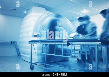 Preparazione al processo di scansione RM di una persona gravemente malata nel reparto di radiologia ospedaliero. Foto Stock