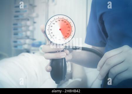 Manometro con zona rossa marcata di pressione alta in mano del medico. Foto Stock