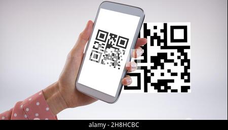 Mano ritagliata di donna che scansiona il codice qr con il telefono cellulare con spazio di copia su sfondo bianco Foto Stock