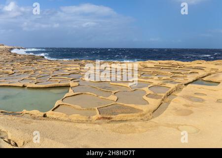 Le saline di Xwejni a Gozo, Malta. Un pittoresco paesaggio di Saline utilizzato per la produzione tradizionale di sale marino e il Mar Mediterraneo Foto Stock