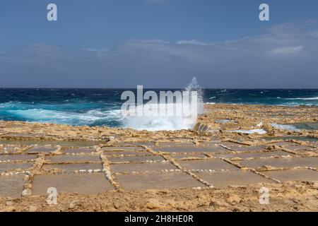 Le saline di Xwejni a Gozo, Malta. Un pittoresco paesaggio di Saline utilizzato per la produzione tradizionale di sale marino e il Mar Mediterraneo Foto Stock