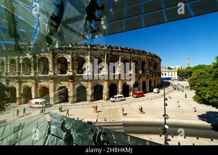 Francia, Gard, Nimes, Place des Arenes, le Arenas e il museo della romanità (Musée de la Romanite) dell'architetto Elizabeth de Portzamparc, struttura interna della facciata in vetro e vista dell'Arena di Nimes Foto Stock