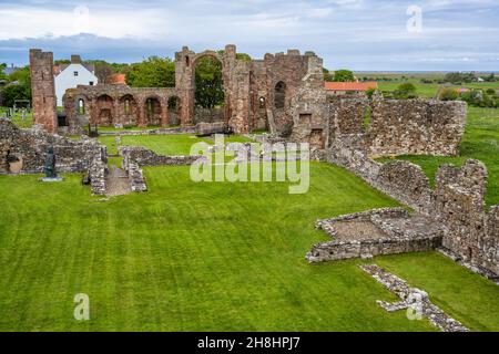 Vista delle rovine del Priorato di Lindisfarne dal Heugh sull'Isola Sacra sulla costa del Northumberland d'Inghilterra, Regno Unito Foto Stock