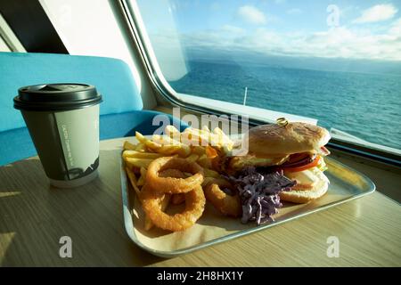 pollo hamburger cipolla anelli coleslaw e patatine pasto su un traghetto che attraversa il mare irlandese Foto Stock