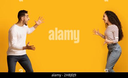 Grande fortuna. Coppia mediorientale gioiosa che alza le mani e esclama con entusiasmo Foto Stock