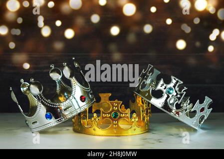 Tre corone dei tre saggi con luci di Natale su un tavolo. Concetto per dia de Reyes Magos giorno. Tre saggi Foto Stock