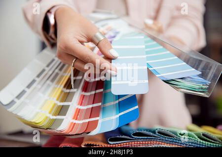 Primo piano mano di donna decoratore, interno e grafico designer, ARCHITECT sta scegliendo catalogo colori ral per il progetto web. Foto Stock