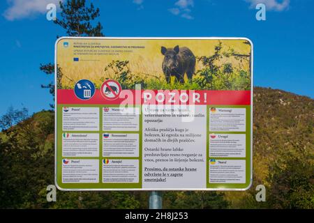 Nova Gorica, Slovenia - 23 ottobre 2021. Un avvertimento in 10 lingue sulla peste suina africana in un parcheggio ai piedi del Monte Skabrijel Foto Stock