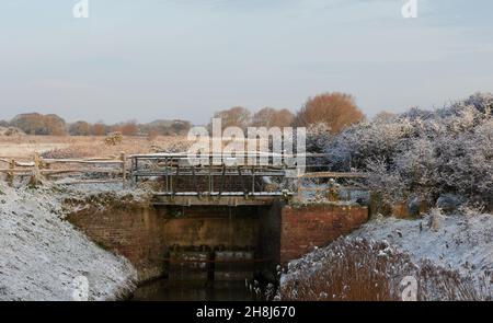 Sluice alla riserva naturale di Porto di Pagham visto coperto con una polvere di neve nel novembre 2021. Foto Stock