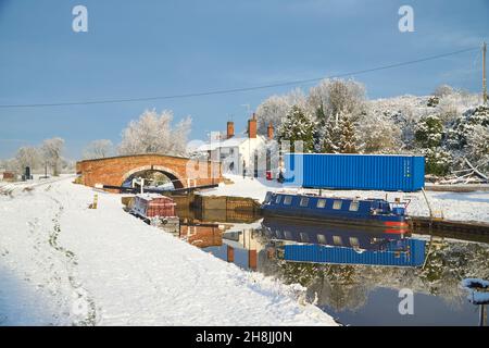 In inverno, una barca stretta ormeggiata vicino a un ponte sul canale Foto Stock