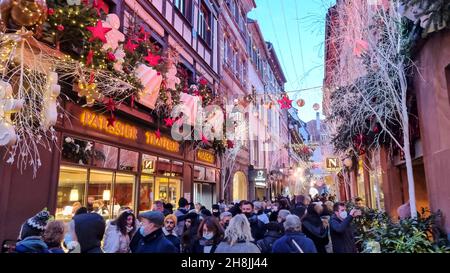 Crowdy strada dello shopping a Strasburgo nel periodo natalizio. Le persone indossano maschere protettive per il viso. Foto Stock