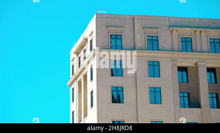 Moderno edificio neoclassico con intenso cielo blu riflesso nelle finestre e spazio negativo per la copia Foto Stock