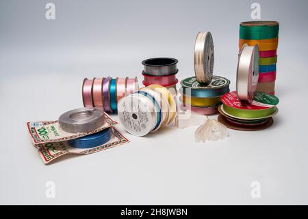 Nastri decorativi vecchi, principalmente su bobine. Nastri del tipo utilizzabile per l'imballaggio di regali. Foto Stock