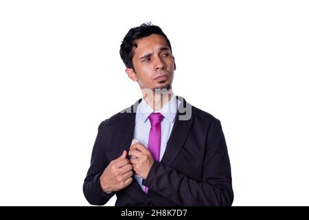 Uomo d'affari segretamente che prende i soldi. Il giovane adulto vestito con abiti eleganti mantiene il denaro nel suo sacco con aspetto sospetto, isolato su tutti Foto Stock