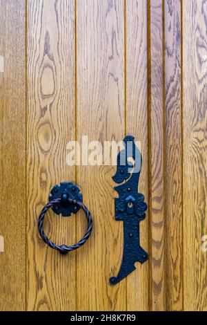 Porta in legno con manico in ferro nero Foto Stock