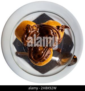 Crema profiteroles con cioccolata calda Foto Stock