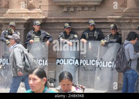 Perù polizia tumulto con scudi in strada a Carnival Cusco sorridente ufficiale poliziotto pronto attacco fucili a scudo tumulto preparare a livello di gas maschera viso indossare Foto Stock