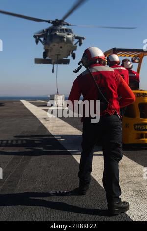 OCEANO PACIFICO (Nov. 9, 2021) i marinai si levano in piedi per trasportare l'ordnance sul ponte di volo a bordo della USS Abraham Lincoln (CVN 72) durante un rifornimento verticale-in-mare. Abraham Lincoln sta conducendo le operazioni di routine nella terza flotta degli Stati Uniti. (STATI UNITI Foto Navy di Mass Communication Specialist terza classe Louis Lea/Released) Foto Stock