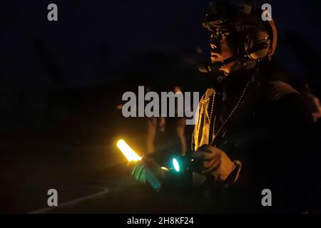 OCEANO PACIFICO (Nov. 17, 2021) Aviation Boatswain's Mate (Handling) 3rd Class Jared Nacion, da Stockton, Calif., dirige gli aerei sul ponte di volo di USS Abraham Lincoln (CVN 72). Abraham Lincoln sta conducendo le operazioni di routine nella terza flotta degli Stati Uniti. (STATI UNITI Foto Navy di Mass Communication Specialist U.S. terza classe Jeremiah Bartelt/Released) Foto Stock