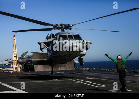 OCEANO PACIFICO (Nov. 11, 2021) Aviation Structural Mechanic Airman Sydney Buckels, di Cleveland, guida un elicottero MH-60 Sea Hawk, assegnato ai 'Chargers' di Helicopter Sea Combat Squadron (HSC) 14, al largo del ponte di volo di USS Abraham Lincoln (CVN 72). Abraham Lincoln sta conducendo le operazioni di routine nella terza flotta degli Stati Uniti. (STATI UNITI Foto Navy di Mass Communication Specialist Seaman Thaddeus Berry/Released) Foto Stock