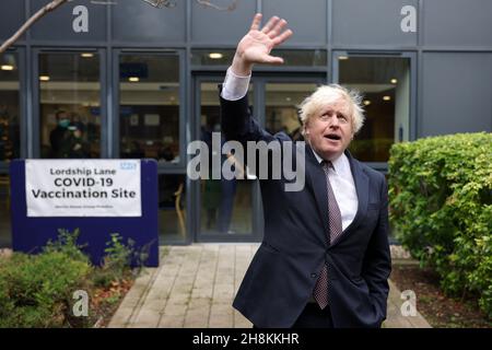 LONDRA, 1 dicembre 2021 (Xinhua) -- il primo ministro britannico Boris Johnson visita un sito di vaccinazione COVID-19 presso il Lordship Lane Primary Care Center di Londra, Gran Bretagna, 30 novembre 2021. Boris Johnson ha detto Martedì che a tutti gli oltre i 18 anni verrà offerto un vaccino di richiamo entro la fine di gennaio e un altro blocco 'estremamente improbabile'. (Andrew Parsons/No 10 Downing Street/Handout via Xinhua) Foto Stock