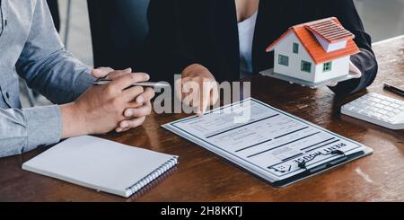 Agente immobiliare ha parlato dei termini del contratto di acquisto domestico, cliente firma i documenti per fare il contratto legalmente, vendite domestiche e casa Foto Stock