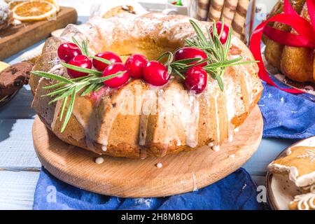 Dolci natalizi fatti in casa, torta di cheesecake dolce con zucchero in polvere, mirtilli e rosmarino. Natale e Capodanno festivo cottura sfondo Foto Stock