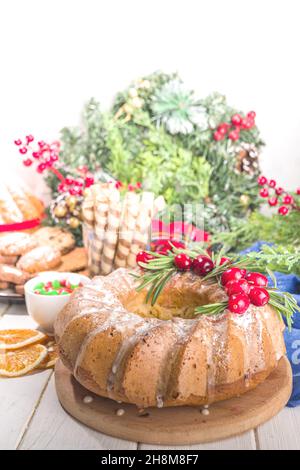 Dolci natalizi fatti in casa, torta di cheesecake dolce con zucchero in polvere, mirtilli e rosmarino. Natale e Capodanno festivo cottura sfondo Foto Stock