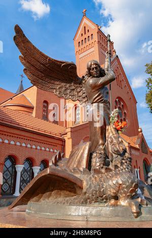 Monumento all'Arcangelo Michele di fronte alla Chiesa Cattolica di San Simone ed Elena a Minsk all'inizio dell'autunno. Bielorussia Foto Stock