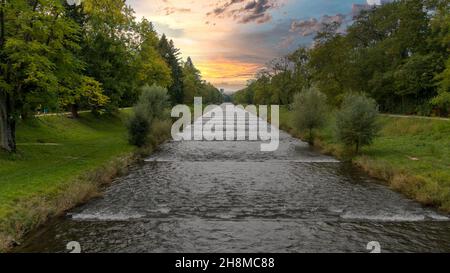 Vista di un fiume con nuvole colorate sullo sfondo Foto Stock